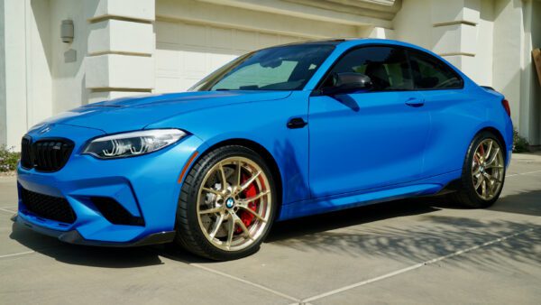View of Blue BMW car with gold rim wheels